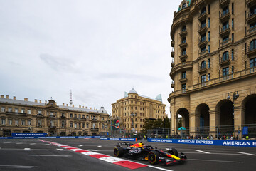 Naklejka premium BAKU, AZERBAIJAN - SEPTEMBER 21, 2025: Max Verstappen drives the Oracle Red Bull Racing RB21 past the historic architecture of Baku during the Formula 1 Azerbaijan Grand Prix