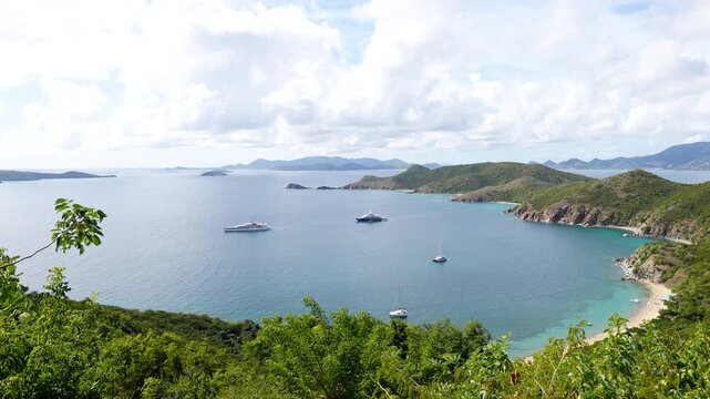 large boats and yachts are anchored and moored in a large bay or cove in the British Virgin Islands in this wide shot of the horizon