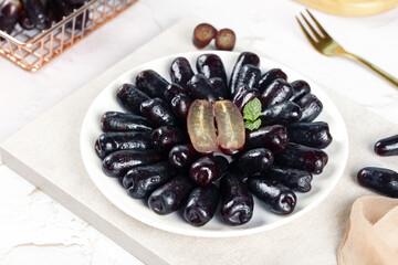 Fresh Black Grapes on White Plate with Elegant Table Setting © NguyenThi