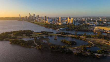 Fototapeta premium Aerial view of Perth city skyline with Boorloo bridge lit up connecting Heirisson island with walking and cycling path along the Swan river