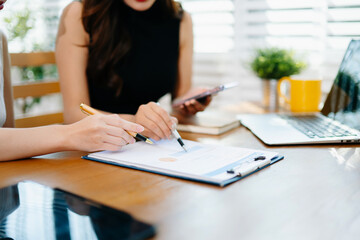 Business documents on office table with smart phone and calculator digital tablet and graph business with social network diagram and two colleagues discussing data working in the office