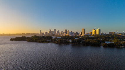 Fototapeta premium Aerial view of Perth city skyline with Boorloo bridge lit up connecting Heirisson island with walking and cycling path along the Swan river