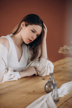 Young beautiful woman model with long hair at the table at home