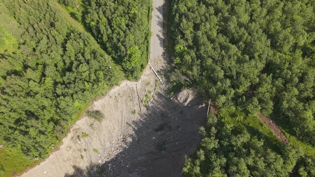 A Forested Slope and a Landslide Cutting Across a Narrow Road at Old E69, Talvik Kr&aring;knesveien, Norway - Aerial Topdown Shot