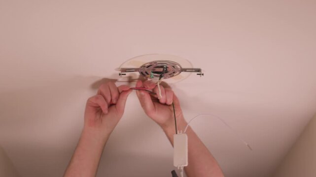 Connecting the copper of the hot wires on the fixture.