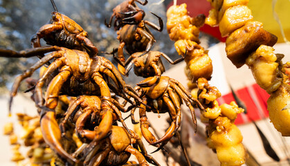River crabs and pieces of meat are skewered and grilled at a roadside food stall during Magh Bihu celebrations, highlighting traditional Assamese street food prepared for the harvest festival