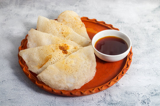 Traditional Bengali chakuli pitha is a soft fermented rice crepe, lightly crisped, mildly sour, cooked on griddle, enjoyed with jaggery, milk, or savory accompaniments.
