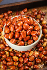 Obraz premium Deep Fried Peanuts Snack in White Bowl on Woven Mat