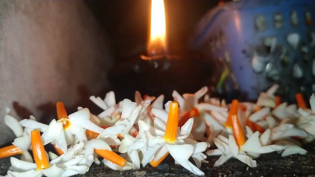 Traditional Oil Lamp with Night Jasmine Flowers Burning in Dark Spiritual Background