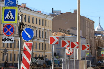 Street infrastructure with several road signs and the direction of movement to the right indicated by white arrows