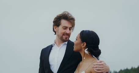 The bride and groom are talking and smiling looking at each other