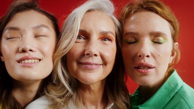 Close-up of the faces of three women of different ages and colors