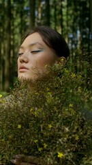 Naklejka premium Woman posing with a bouquet of wildflowers at the edge of the forest, vertical video