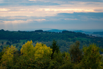 Beautiful cloudscape sunset landscape in the green woods mounts in the Cotswolds, England