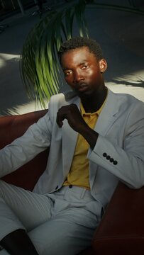 A man sits on a sofa in the lobby of a business center, vertical video
