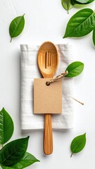 Wooden spoon on linen with green leaves