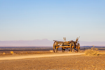 Fototapeta premium Vintage ox wagon abandoned in arid desert