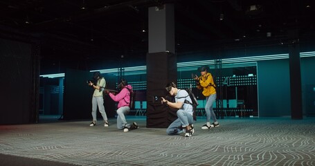 A group of people wearing virtual reality glasses operate a game gun while playing an online video game