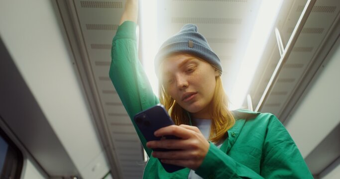 Woman using a mobile phone in a subway car