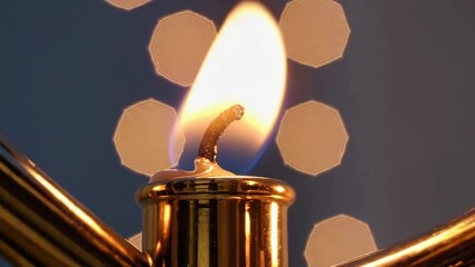 Close-up of a Hanukkah menorah flame with soft bokeh, conveying warmth, tradition, and celebration.