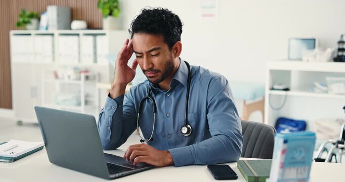 Doctor, man and headache with laptop in office with stress, pain and typing report at hospital. Person, medical professional and frustrated with migraine, burnout or vertigo with pc for clinic admin