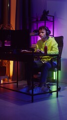 Young man in headphones playing video games on the computer