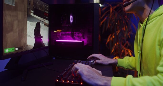 Young man in headphones playing video games on the computer - Powered by Adobe