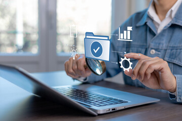 Business document verification and process management concept. Professional using magnifying glass to inspect approved digital files on laptop with workflow, quality control, and optimization icons.