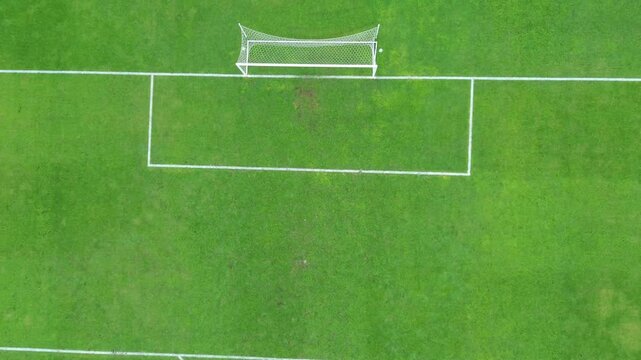 A well-kept football pitch with bright turf, clear lines, and sturdy goalposts at both ends