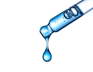 Blue serum drop falling from a pipette