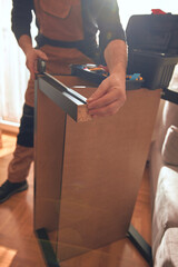 Carpenter working and assembling furniture in a new apartment.