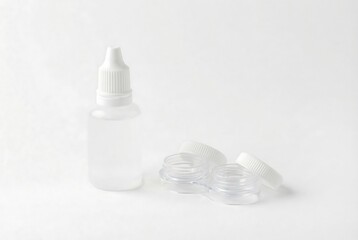 Contact lens solution bottle and case with open lids on white background. Optimal vision health concept. Minimalist eye care accessories for daily use.