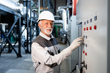 Senior industrial engineer operating control panel in plant