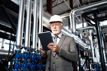 Senior engineer using digital tablet in industrial plant