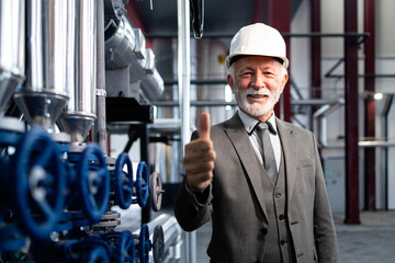Senior manager giving thumbs up in industrial plant