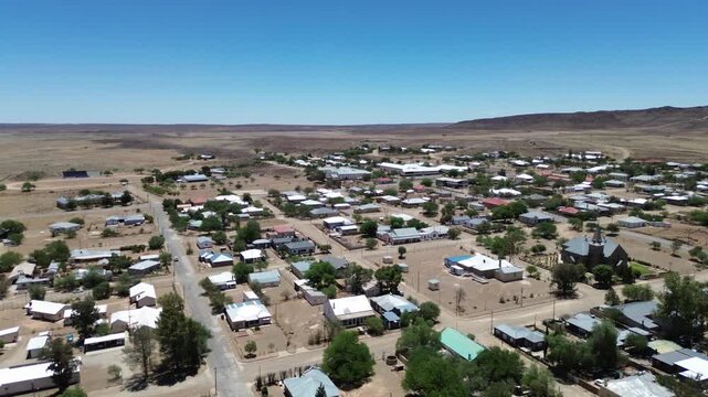 Camera panning left to right over the small Tourist town of Williston in the Karoo dry brown landscape all around the town. 4K Aerial Video.