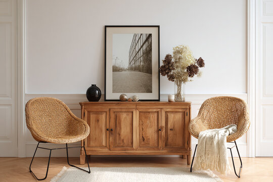 Cozy interior scene featuring two wicker chairs and a wooden sideboard with art and decor