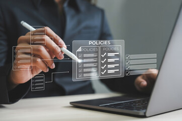 Businessman reviewing company policy and compliance checklist requirements professionally on laptop is a routine task. This process utilizes digital online document on virtual screen technology
