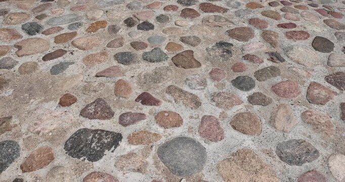 a road made of stones in rural areas, a reconstructed ancient road made of multicolored stones, cobblestones and pebbles