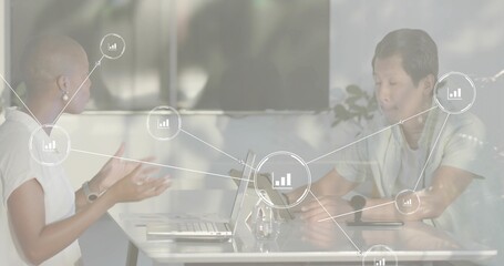 Discussing data three colleagues in business attire at meeting table, with laptop tablet smartphone