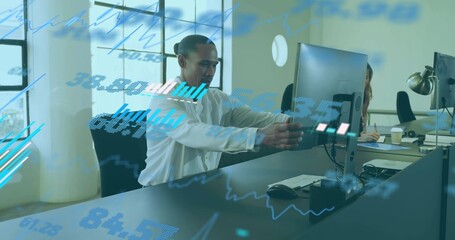 Adjusting man in white shirt moving large monitor at office desk, with financial graphics