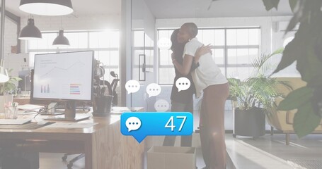 Hugging two women coworkers in work attire at open plan office near box, monitor with charts