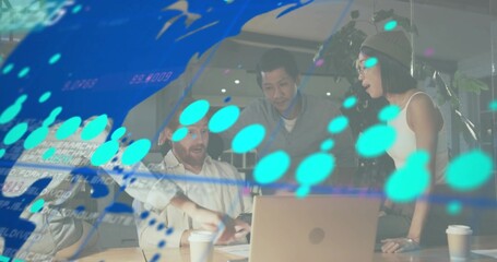 Discussing team leaning over laptop at office table in business attire, showing teal data overlay