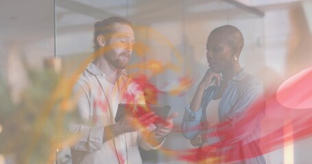 Showing man in shirt gesturing at tablet, woman in denim watching in office with glass-wall, swirls