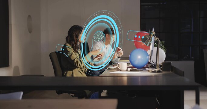 Interacting two coworkers in casual attire using blue hologram at office desk, with balloons - Powered by Adobe
