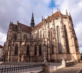 Fototapeta premium St. Elisabeth Cathedral in Košice, Slovakia. Gothic church exterior with detailed stone architecture, stained glass windows, and tiled roof under cloudy sky in historic city center.