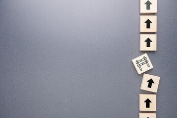 Wooden arrow blocks showing upward progress interrupted by a barrier, representing delay, blockage, and obstacle concept