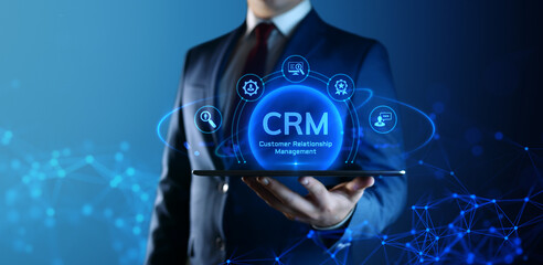 Businessman holding tablet with CRM Customer Relationship Management icons on screen
