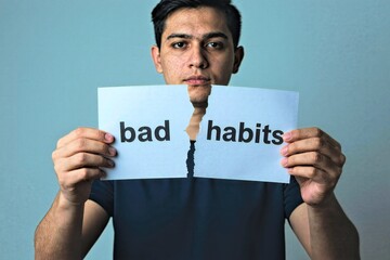 Man Holding Paper Reading "Bad Habits" Covering Face