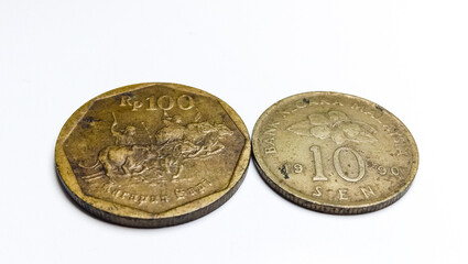 Vintage Malaysia 10 Sen 1990 and Indonesia 100 Rupiah Karapan Sapi coins. Both coins are displayed on a clean white background with natural aged patina. © FalOpang
